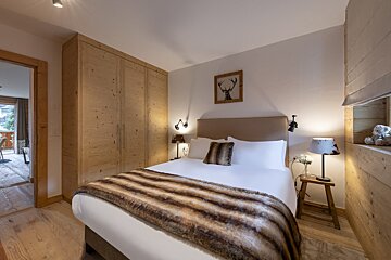 A bedroom with a bed and a picture of a deer on the wall