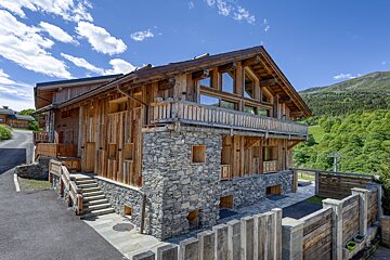 A large wooden and stone building with stairs leading up to it