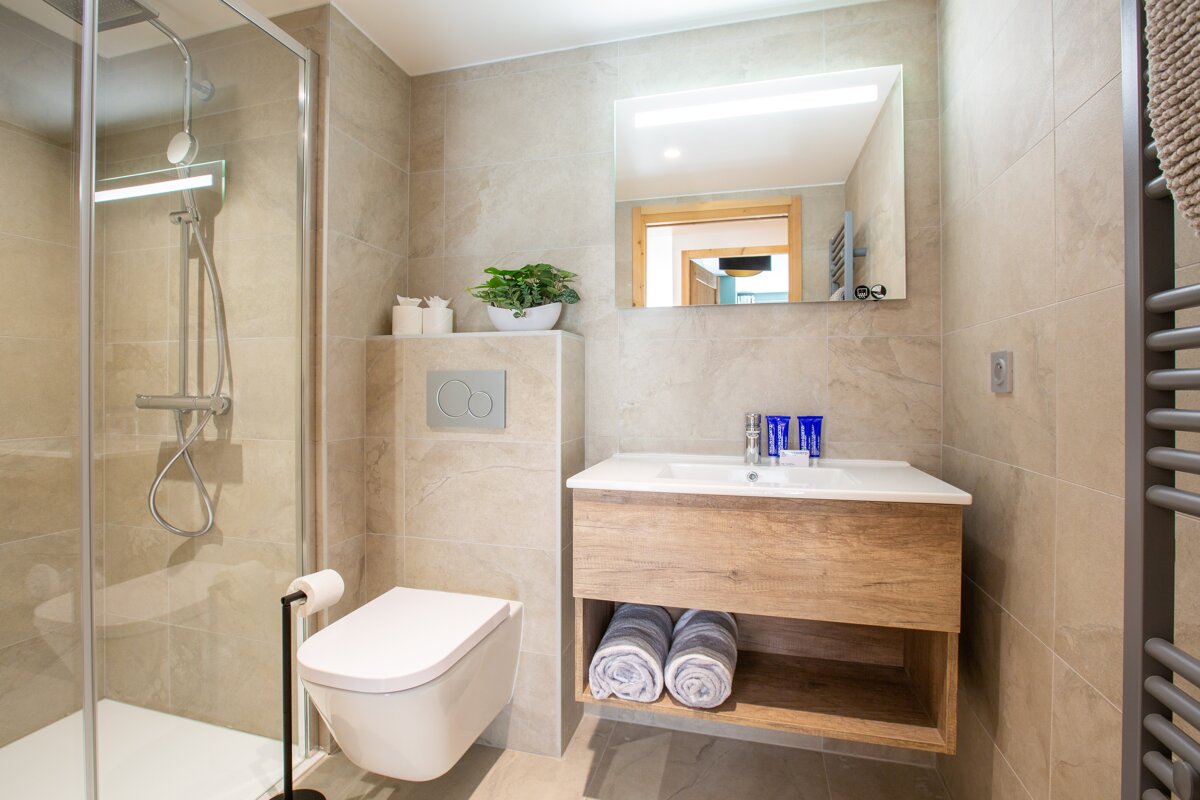 A bathroom with a toilet a sink and a mirror