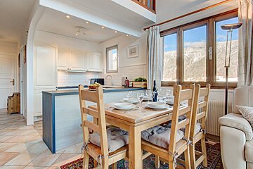 A dining room table with a bottle of wine on it