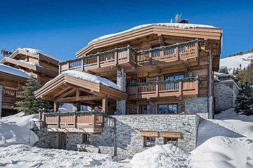 A large wooden house with snow on the roof