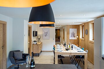A bottle of champagne sits on a table in a dining room