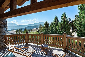 A balcony with a view of mountains and trees