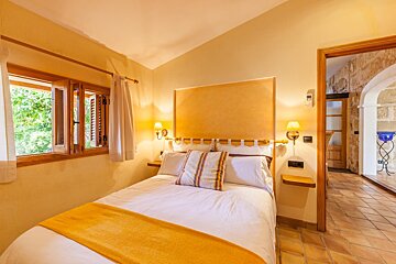 A bedroom with a large bed and a window