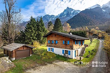 A house with blue shutters is for sale by mountain base