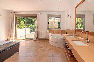 A bathroom with a bathtub and two sinks