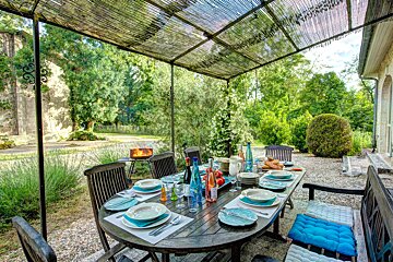 A table with plates and utensils on it under a canopy