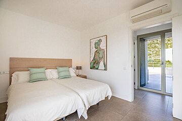 A bedroom with two beds and a painting on the wall