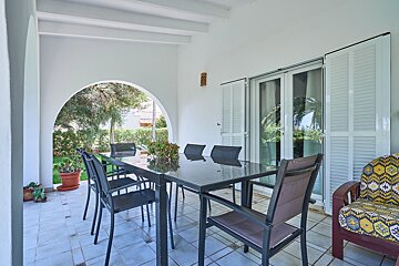 A patio with a table and chairs and a sliding glass door