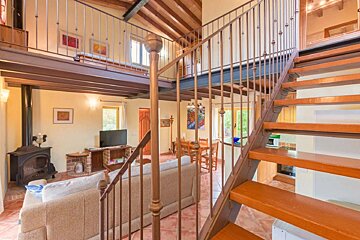 A living room with stairs leading up to the second floor
