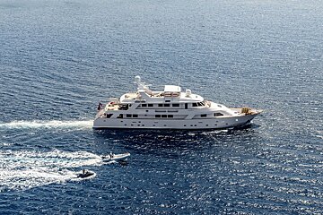 A large white yacht is in the middle of the ocean