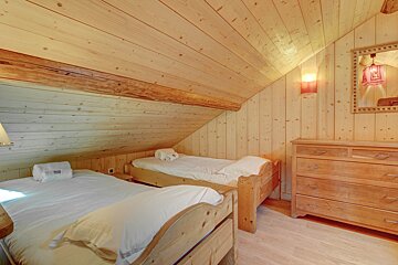 A bedroom with two twin beds and a dresser