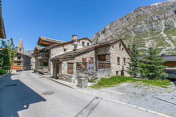 A stone building with a sign on the side that says ' alquiler '