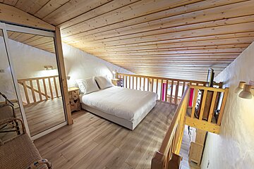 A bedroom with a bed and a mirror on the wall