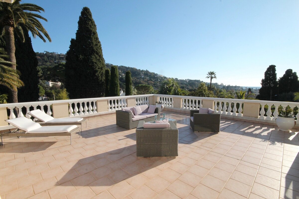 A balcony with a couch and chairs on it