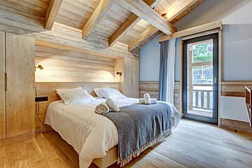 A bedroom with a large bed and a window
