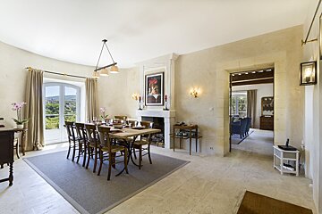 A dining room with a table and chairs and a fireplace