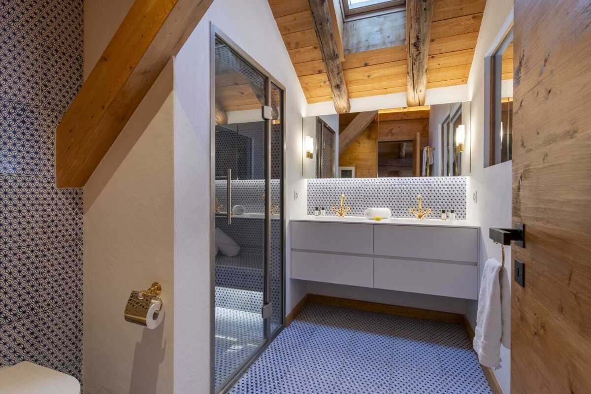 A bathroom with two sinks and a walk in shower