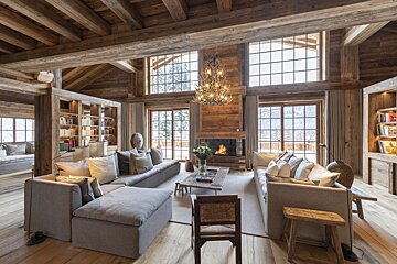 A living room filled with furniture and a fireplace with a bookshelf with a book titled