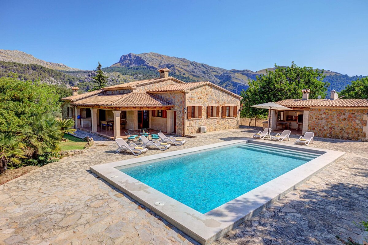 A house with a large swimming pool in front of it