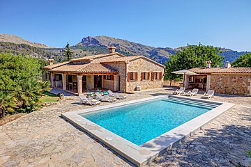 A house with a large swimming pool in front of it