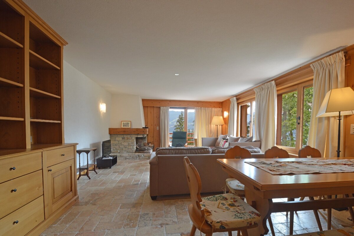 A living room with a table and chairs and a fireplace