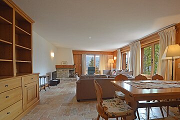 A living room with a table and chairs and a fireplace