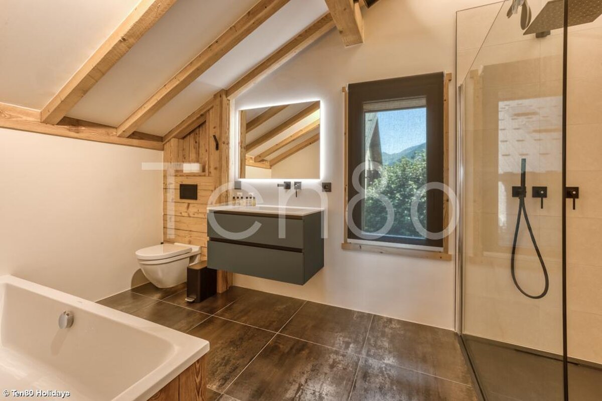 A bathroom with a bathtub and a toilet with the word holidays in the corner
