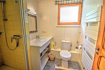 A bathroom with a toilet a sink and a window