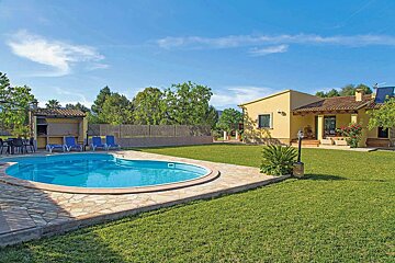 A house with a large swimming pool in front of it