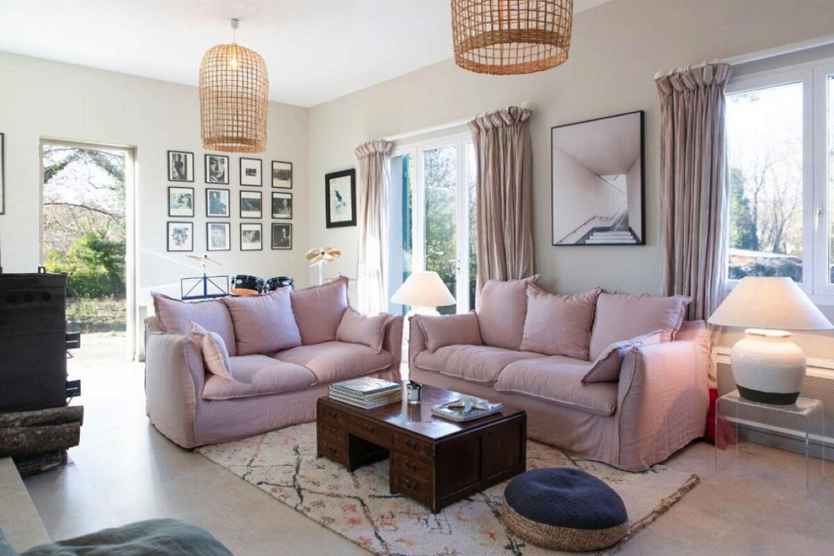 A living room with two pink couches and a coffee table