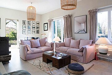 A living room with two pink couches and a coffee table