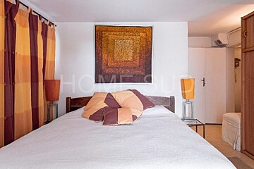 A bedroom with a bed and a painting that says home