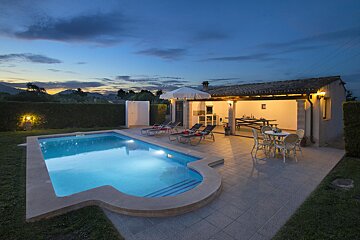 A house with a large swimming pool in front of it
