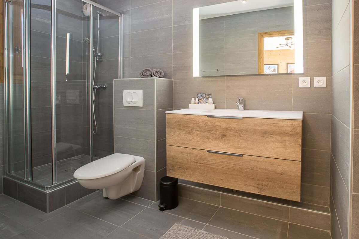 A bathroom with a toilet a sink and a mirror