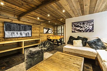 A living room with a game table and a flat screen tv