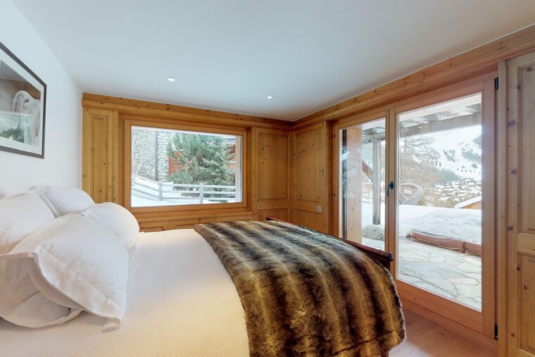 A bedroom with a large bed and a large window