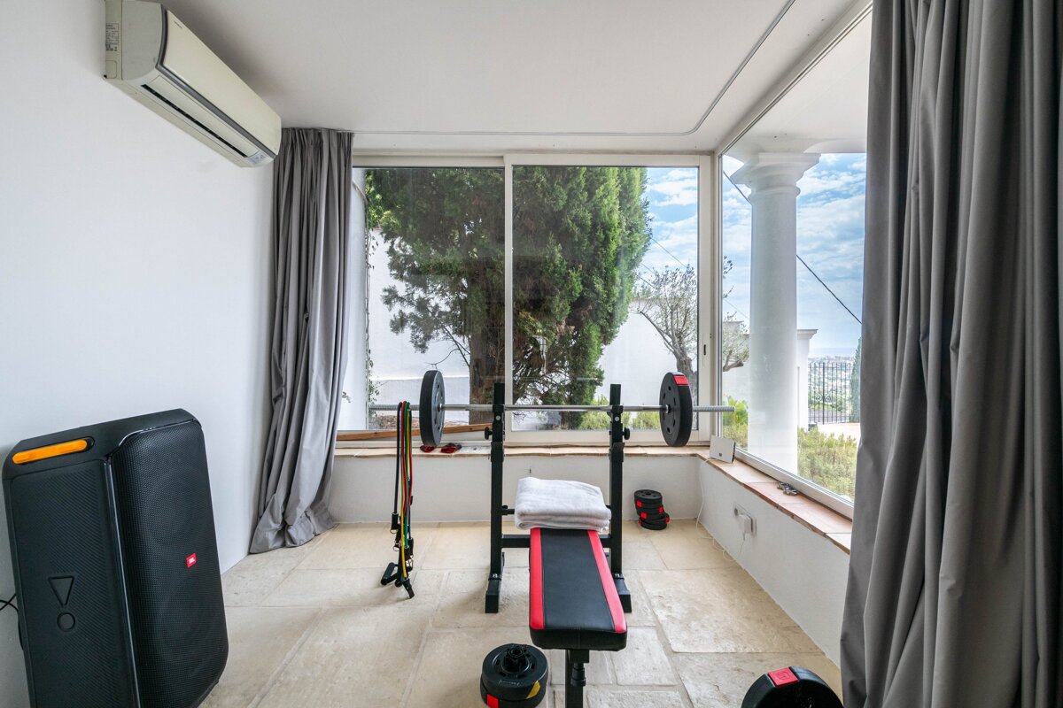 A gym with a jbl speaker and a bench