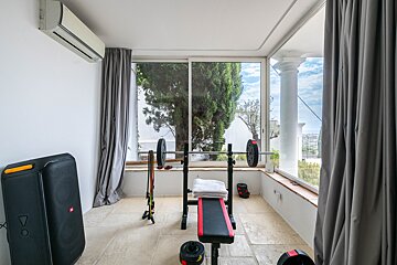 A gym with a jbl speaker and a bench