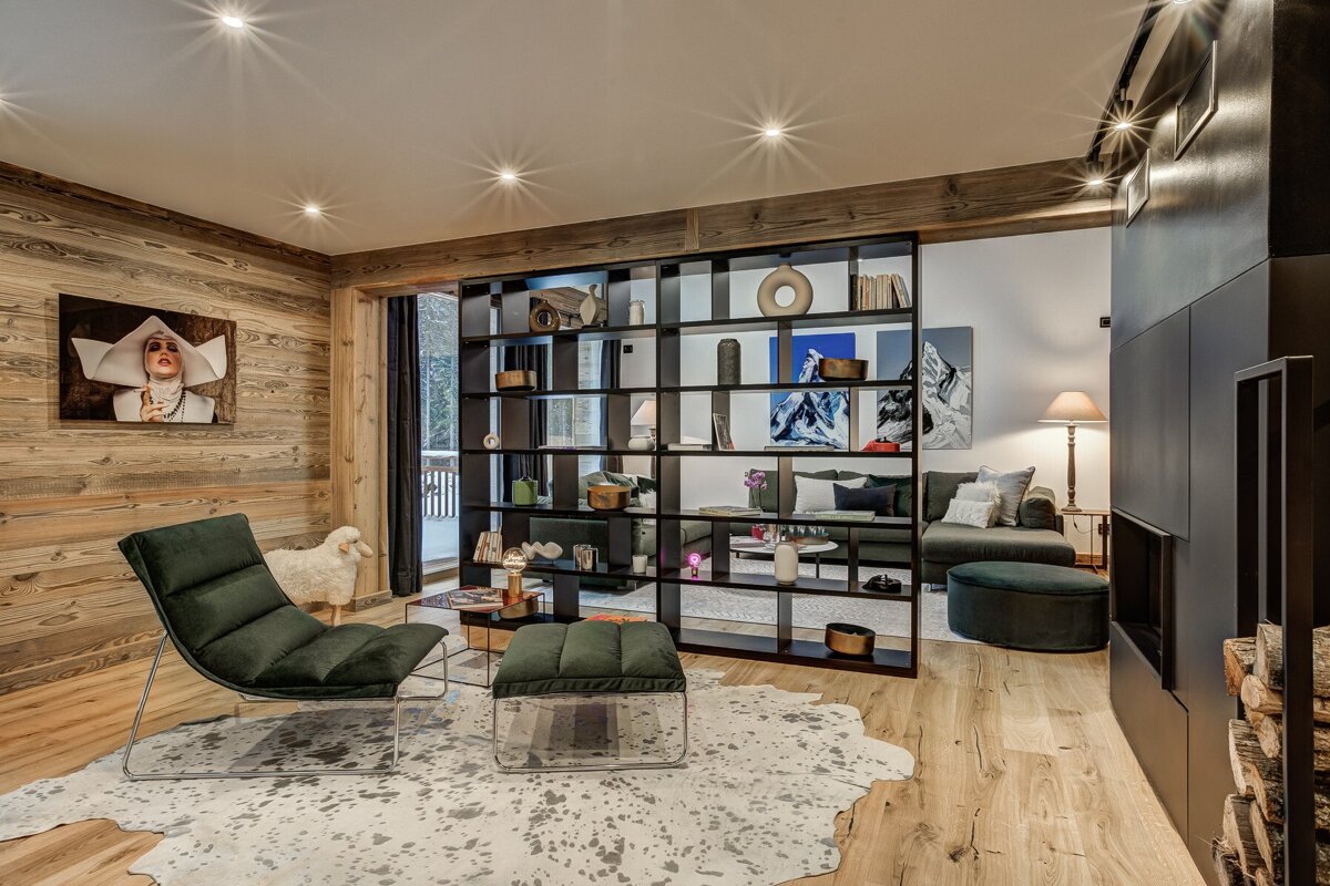 A living room with a green chair and a cowhide rug