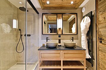 A bathroom with two sinks and a walk in shower