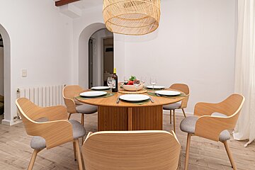 A dining room table with a bottle of wine on it