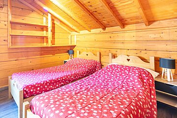 A bedroom with two beds and two lamps