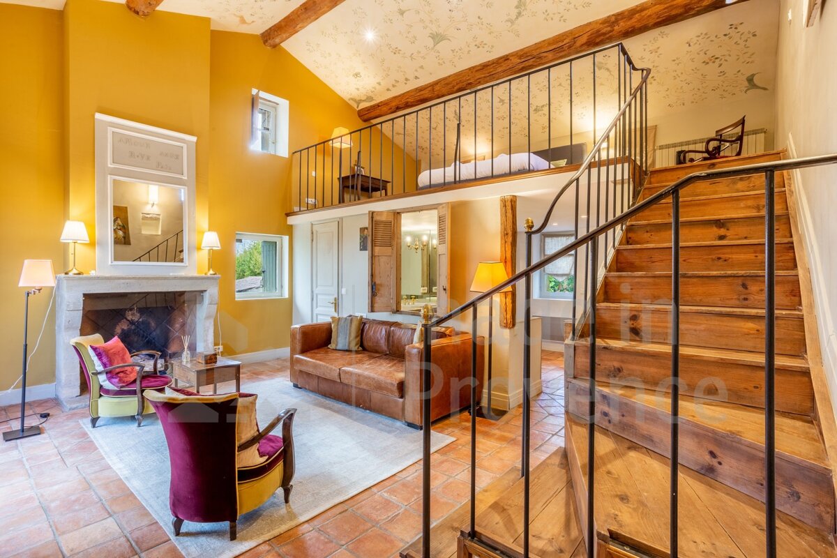 A living room with a staircase leading up to a bedroom