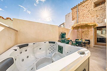 A hot tub with a table and chairs in the background