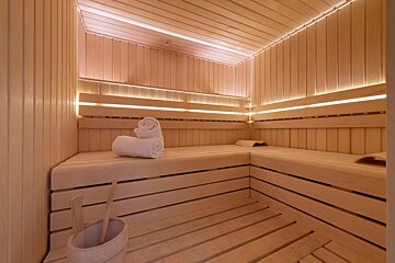 A wooden sauna with towels and a wooden bucket