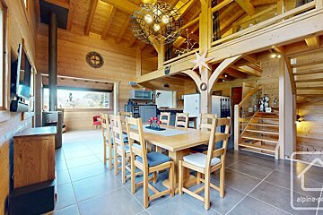 A wooden house with a large dining table and chairs