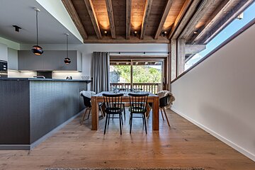 A dining room with a wooden table and chairs