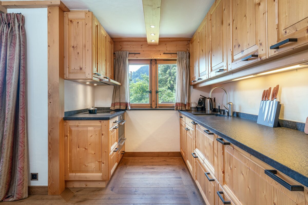 A kitchen with wooden cabinets and black counter tops