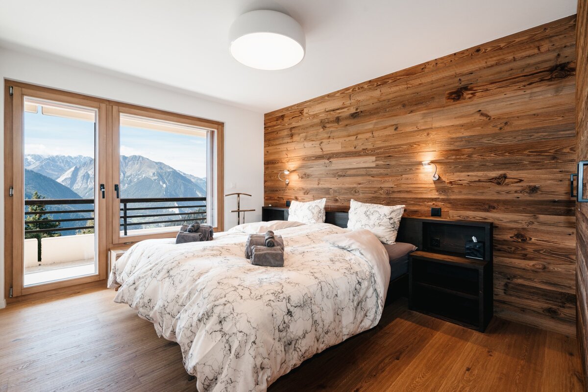 A bedroom with a bed and a view of the mountains